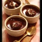 Delicious chocolate pudding pots garnished with whipped cream and chocolate shavings