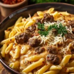 Creamy beef pasta dish served in a bowl with parsley garnish.