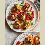Goat cheese stuffed mini peppers appetizer on a platter.