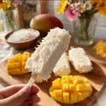 Delicious Mango Magnum Popsicles with coconut flavor on a wooden stick