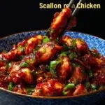 Plate of Chinese Scallion Chicken garnished with fresh scallions and herbs.