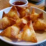 Delicious Crab Rangoon, crispy dumplings filled with cream cheese and crab meat.