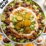 Delicious Big Mac Salad with lettuce, tomatoes, pickles, and dressing in a bowl.