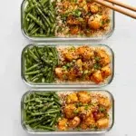 Plate of Honey Sriracha Chicken with Green Beans garnished with sesame seeds