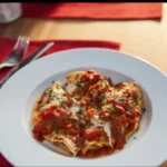 Baked stuffed shells with meat, cheese, and tomato sauce on a plate.